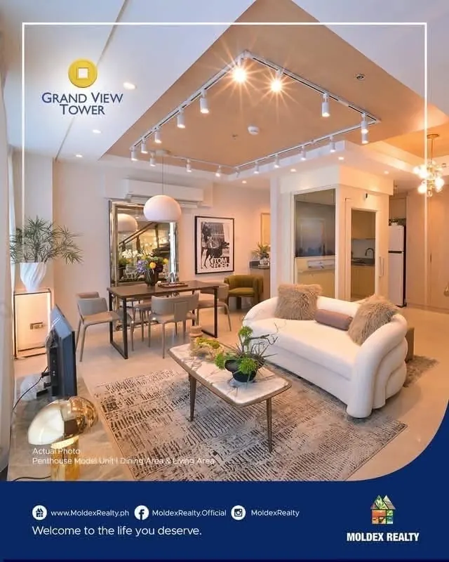 Photo showing the penthouse model's dining table and living area under a track-lit wood ceiling